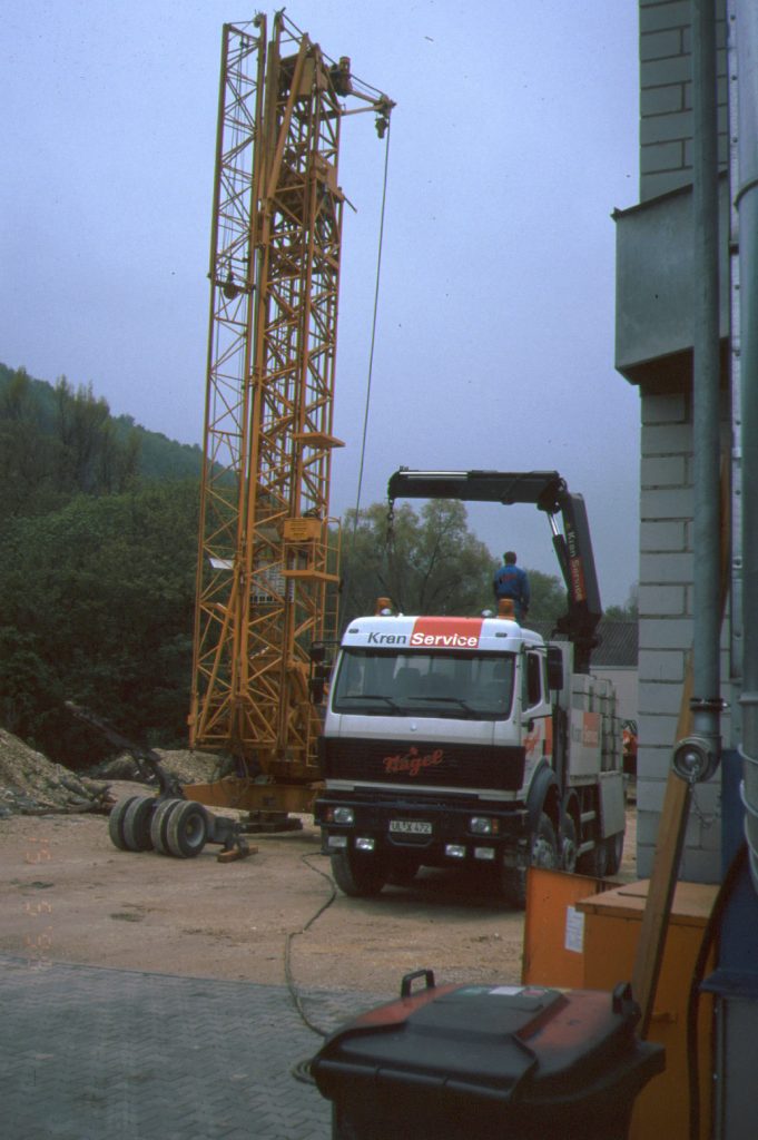 Autkran baut einen gelben Kran auf.