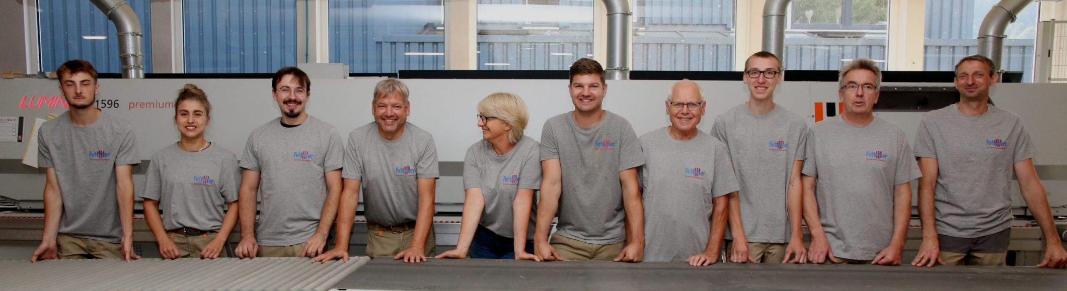 Das Team der Schreinerei Fetscher in einer Reihe mit Arbeitsklamotten